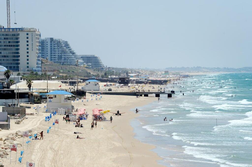 אנשים מבלים בחוף הים במהלך גל חום קיצוני