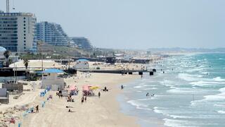 אנשים מבלים בחוף הים במהלך גל חום קיצוני