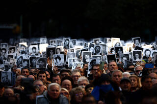 People hold pictures of victims during a ceremony to commemorate the anniversary the Mutual Israelite Association of Argentina (AMIA) bombing attack in Buenos Aires on July 18, 2024 