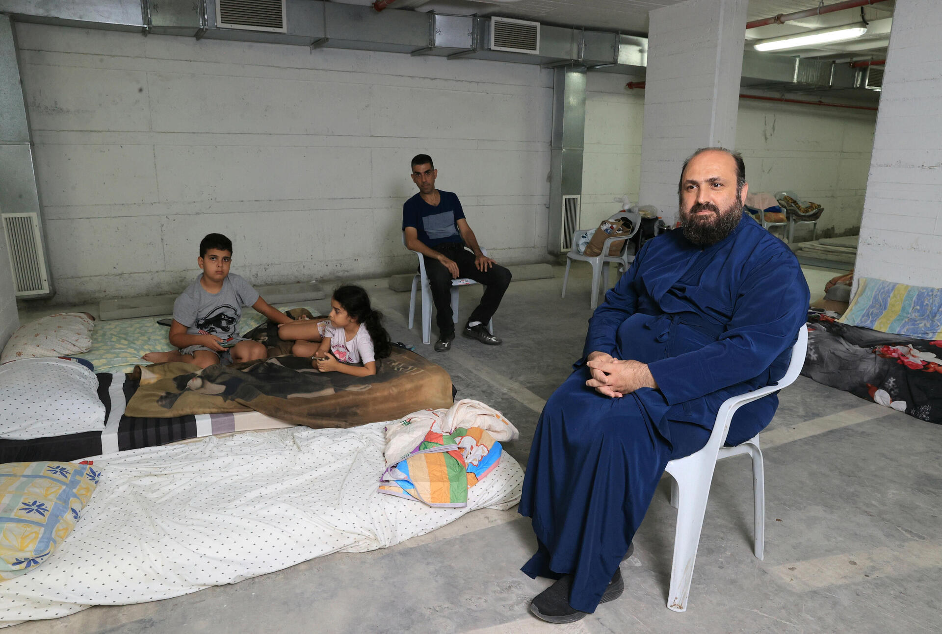 הכומר ארתימיוס בחניון התת-קרקעי של כנסיית יוחנן המטביל, שהפך למקלט המוני 