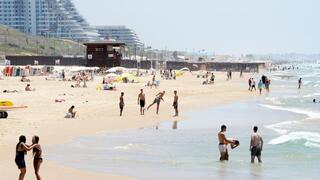 אנשים מבלים בחוף הים במהלך גל חום קיצוני