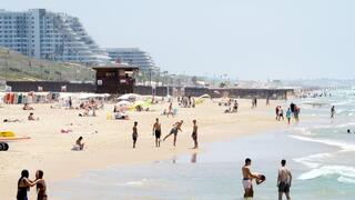 אנשים מבלים בחוף הים במהלך גל חום קיצוני