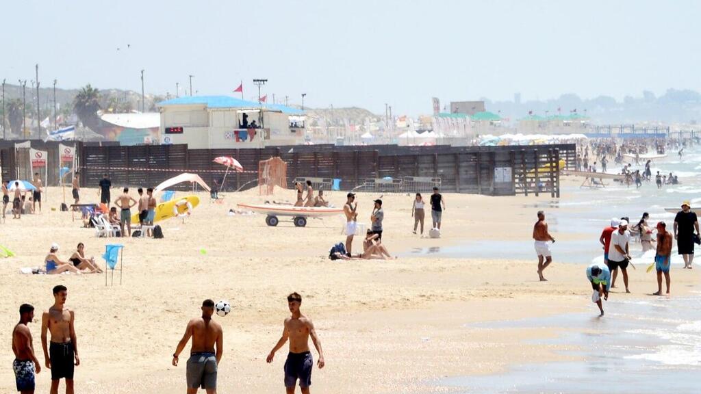 אנשים מבלים בחוף הים במהלך גל חום קיצוני