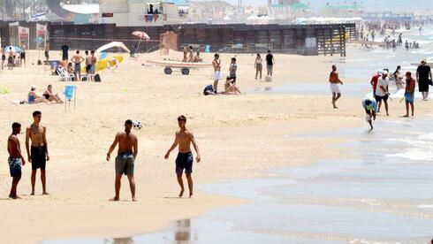 אנשים מבלים בחוף הים במהלך גל חום קיצוני