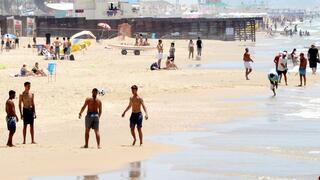 אנשים מבלים בחוף הים במהלך גל חום קיצוני