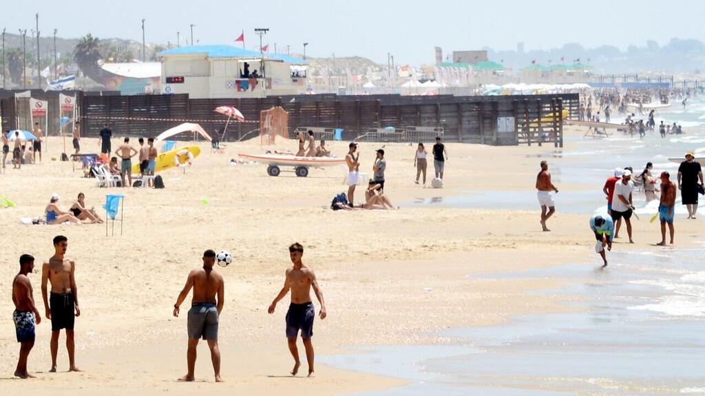 אנשים מבלים בחוף הים במהלך גל חום קיצוני