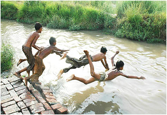 Boys swimming in a water source in Pakistan
