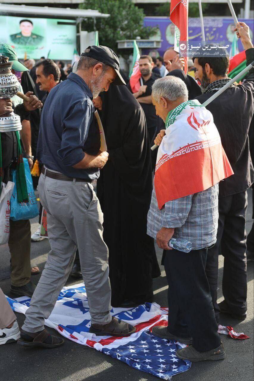 אזרחים איראנים דורכים על דגלי ישראל וארצות הברית