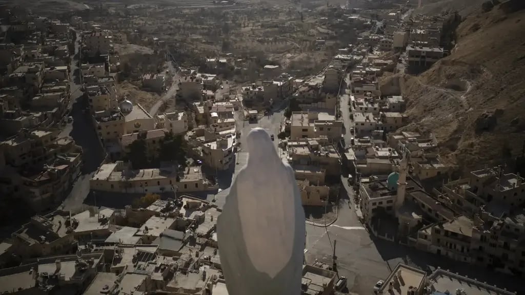 A statue of the Virgin Mary stands on the top of a cliff with a view of the houses of Maaloula, a village where Aramaic is still spoken, located some 60 km northern Damascus, Syria