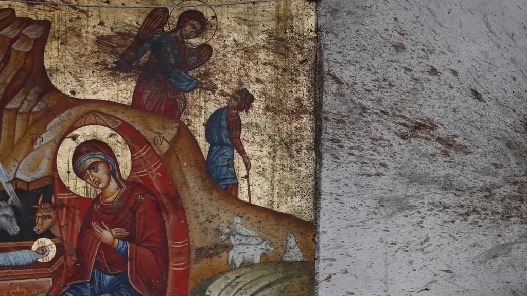Blood stains a religious icon of the Virgin Mary and child inside the Mar Elias Greek Orthodox Church in Dweil'a on the outskirts of Damascus, Syria