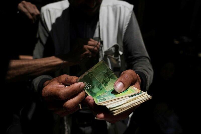 Another problem Nassar points to is the flood of Israeli shekels in the Palestinian market (Photo: AP Photo/Jehad Alshrafi) סחר במזומן ישראלי ישן בעזה