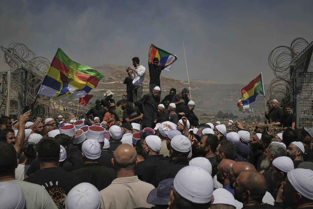 Dozens of Israeli Druze demonstrators breach Syria border fence (Photo: AP Photo/Leo Correa, REUTERS/Khalil Ashawi) דרוזים חוצים לתוך גבול סוריה