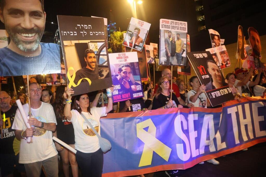 Families and supporters of hostages held in Gaza hold signs and photos of their loved ones during a protest calling for a deal to secure their release, in Tel Aviv, July 26, 2025 (Photo: Moti Kimchi) אלפים צועדים לשגרירות ארצות הברית בתל אביב