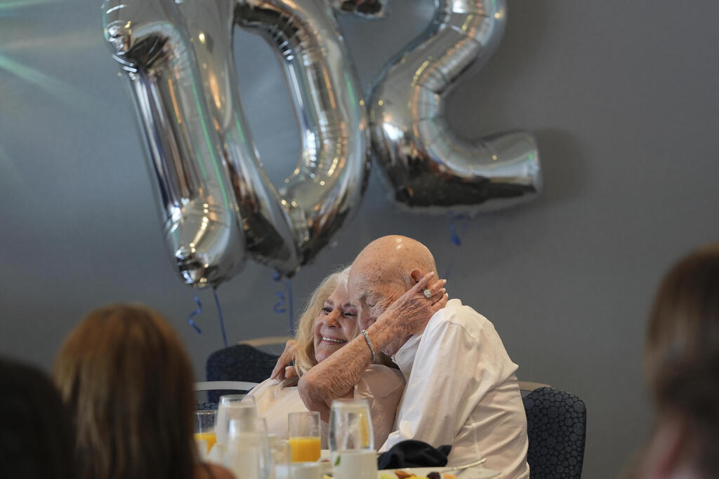 Jeanne Swerlin embraces her husband Harold Terens,  a World War II veteran who fought in D-Day, as they listen to speeches by his family while celebrating his 102 birthday, Saturday, July 26, 2025, in Delray Beach, Fla. 