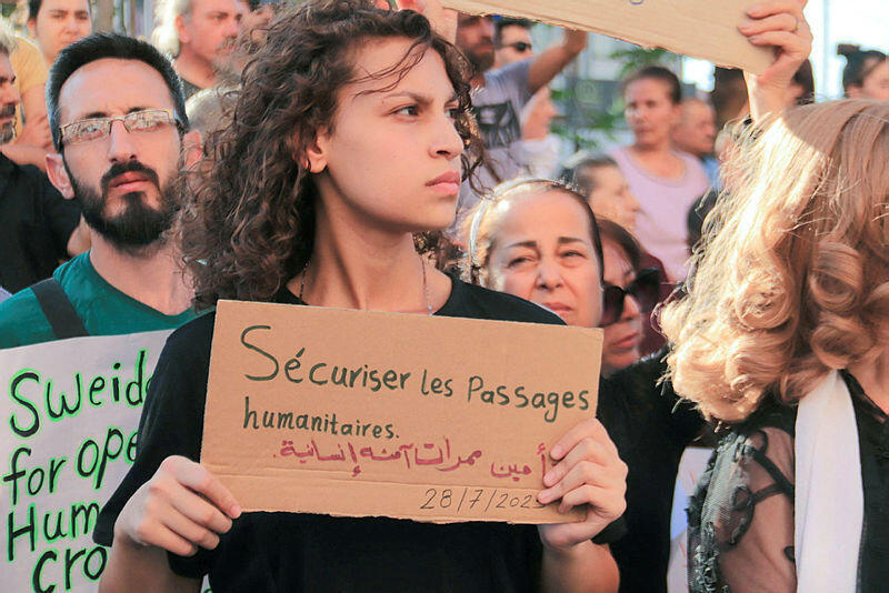 A Syrian carries a placard during protest of the humanitarian situation in the predominantly Druze city of Sweida on July 28, 2025