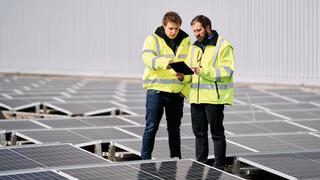 עובדי טבע על גג פאנלים סולאריים באתר החברה בגרמניה