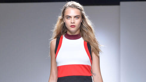 קארה דלווין מדגמנת בתצוגת אביב-קיץ 2015 של טופשופ יוניק בשבוע האופנה בלונדון