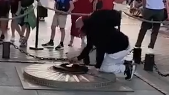 מהגר מרוקני ב צרפת מדליק סיגריה מאש התמיד באנדרטת החייל האלמוני שמתחת ל שער הניצחון ב פריז