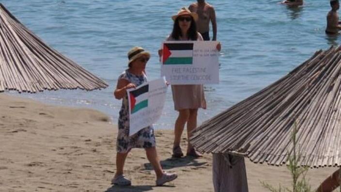 Protesters displaying the Palestinian flag at the beach (Photo: BDS) יום הזעם ביוון