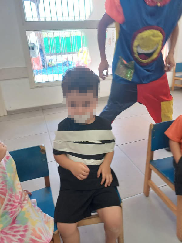 ליצן קשר ילד לכיסא במהלך פעילות במעון