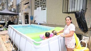 עם שניים מהילדים בבריכה מאולתרת בחצר הבניין