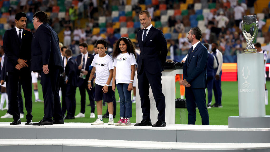 UEFA President Aleksander Ceferin with Gazan children at European Super Cup medal ceremony (Photo: Claudio Villa/Getty Images) טאלה ומוחמד לצד נשיא אופ"א, אלכסנדר צ'פרין, בטקס הענקת המדליות