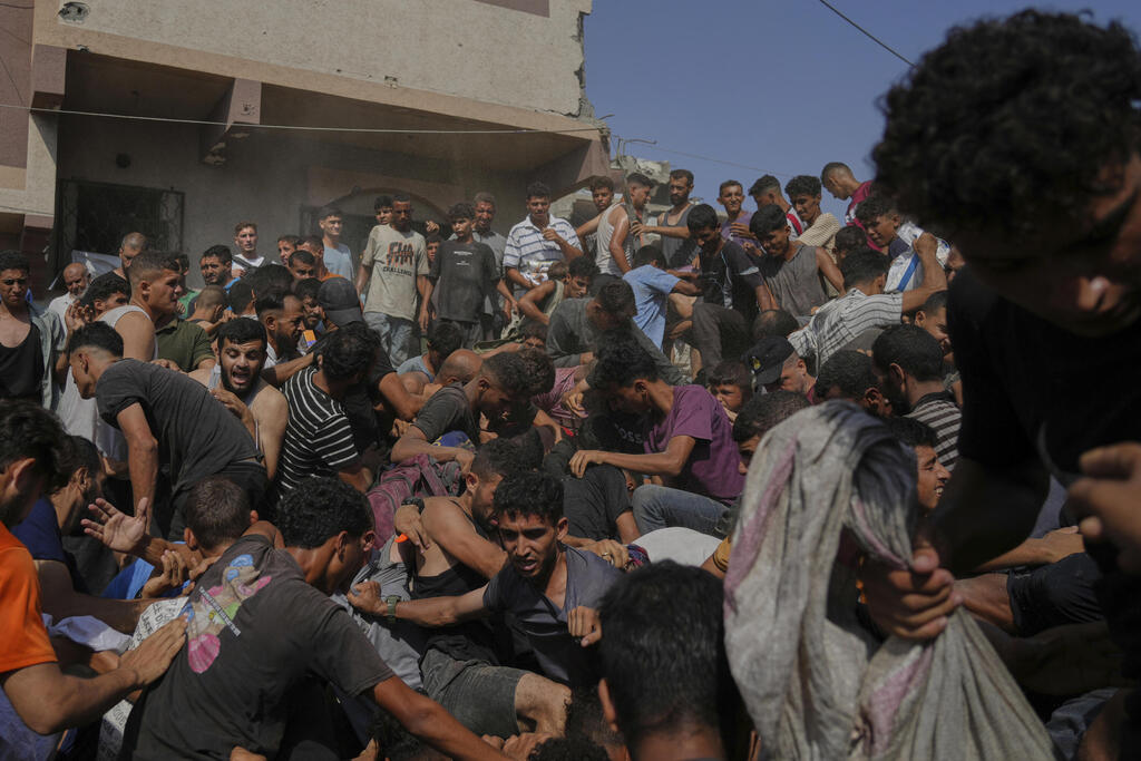 פלסטינים אוספים סיוע המניטרי אחרי שהוצנח