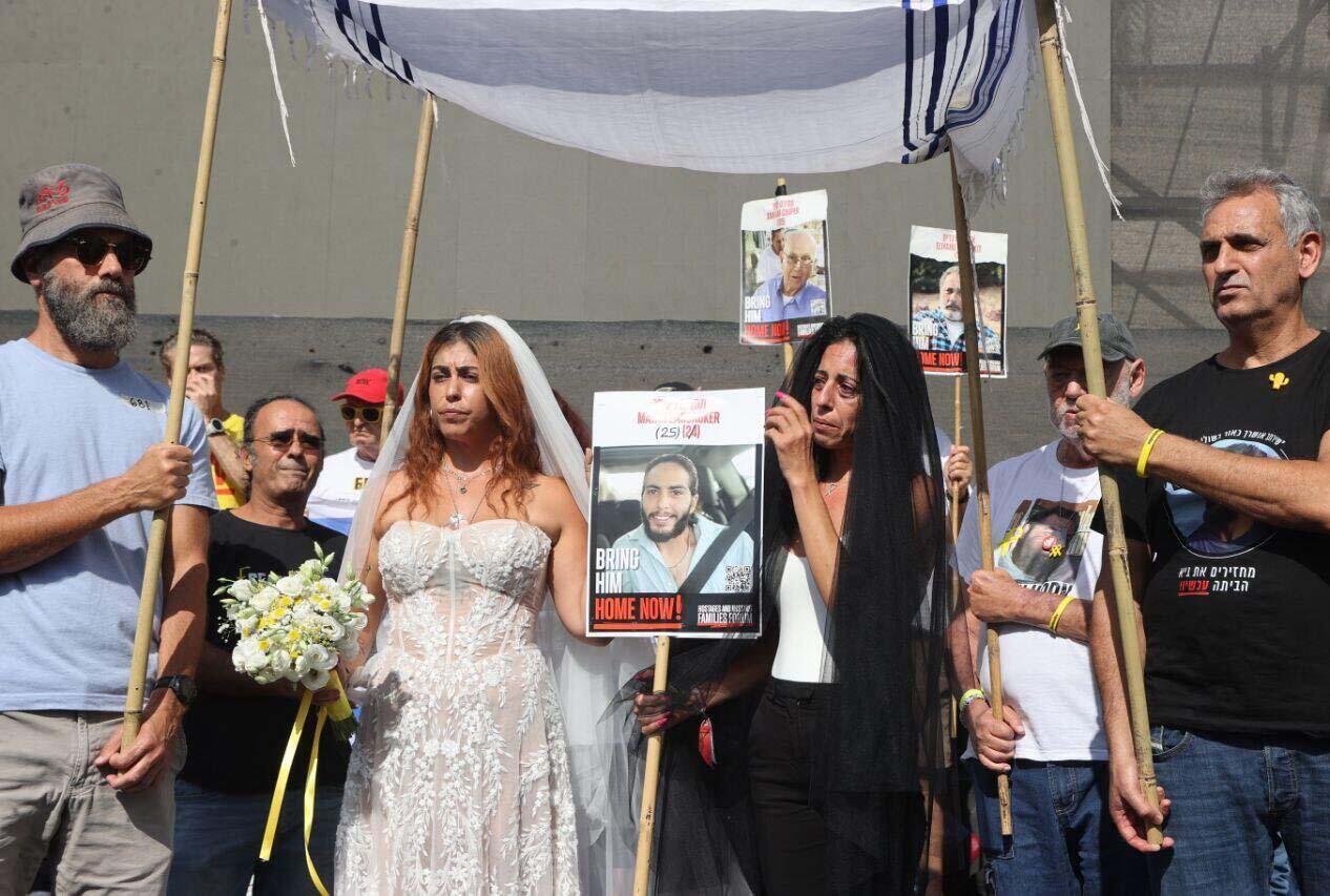 אילנה גריצ'ווסקי, בת הזוג של החטוף מתן צנגאוקר, עם שמלת כלה במיצג כואב בכיכר החטופים 