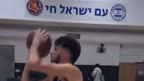 צ'ט הולמגרן זורק לסל על רקע דגלי ישראל ועם ישראל חי