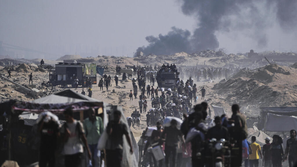 Эвакуация гражданского населения в Газе (Фото: AP Photo/Abdel Kareem Hana) עזתים נושאים סיוע הומניטרי, על רקע תקיפה של צה"ל
