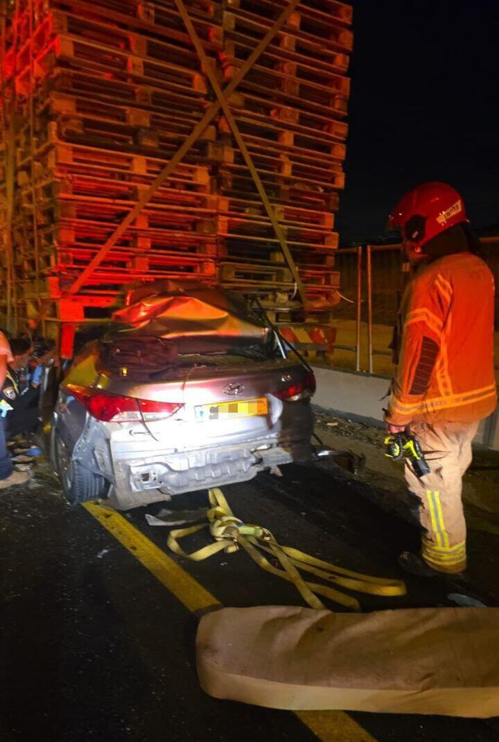 Машину зажало под грузовиком (Фото: Служба спасения (Кабаут ве-ацала)) תיעוד זירת התאונה הקטלנית בכביש 6