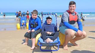 ילדים מאובחני דושן-בקר מעמותת "צעדים קטנים" גולשים בבת ים עם מתנדבי עמותת "הגל שלי"