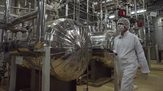 An Iranian security official in protective clothing walks through part of the Uranium Conversion Facility just outside the Iranian city of Isfahan, March 30, 2005 