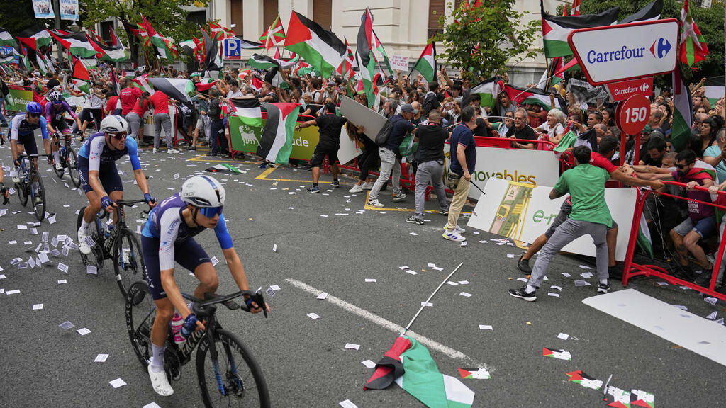 Pro-Palestinian Protesters try to storm the course and disrupt Israel Premier Tech riders during stage 11 of the Vuelta (Photo: AP/ Miguel Oses) מוחים מנסים לפרוץ למסלול ולהפריע לרוכבי הקבוצה ישראל פרמייר טק בקטע ה-11 של וואלטה