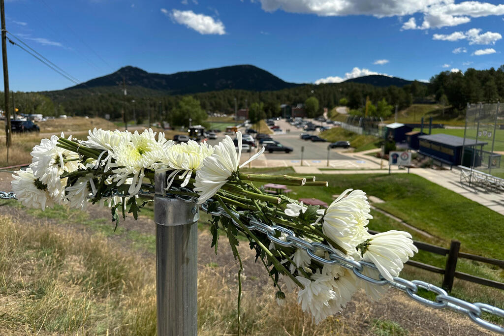 Flowers are left in remembrance of those wounded in a shooting at Evergreen High School in Evergreen, Colo.