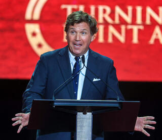 טאקר קרלסון ב טקס לזכר צ'רלי קירק  באצטדיון ב גרנדייל אריזונה ארה"ב