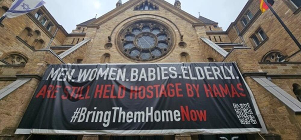שלט לשחרור החטופים, שנתלה בחזית בית הכנסת הגדול ברחוב Roonstraße בקלן