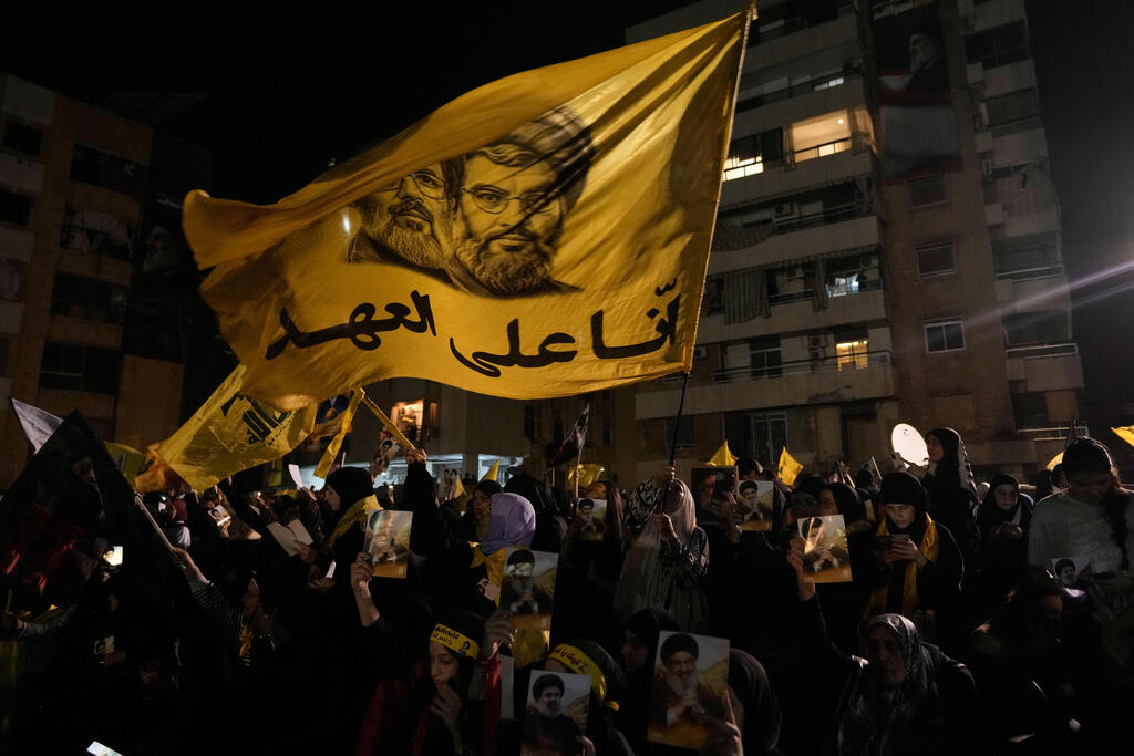 Hezbollah supporters during an event marking the anniversary of the assassination of Hezbollah leader Hassan Nasrallah in Beirut (Photo: Hassan Ammar/AP) תומכי חיזבאללה במהלך אירוע לציון יום השנה לחיסול מנהיג חיזבאללה, חסן נסראללה, בביירות
