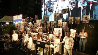 נינט שרה בעצרת, כשברקע עומדים שורדי שבי