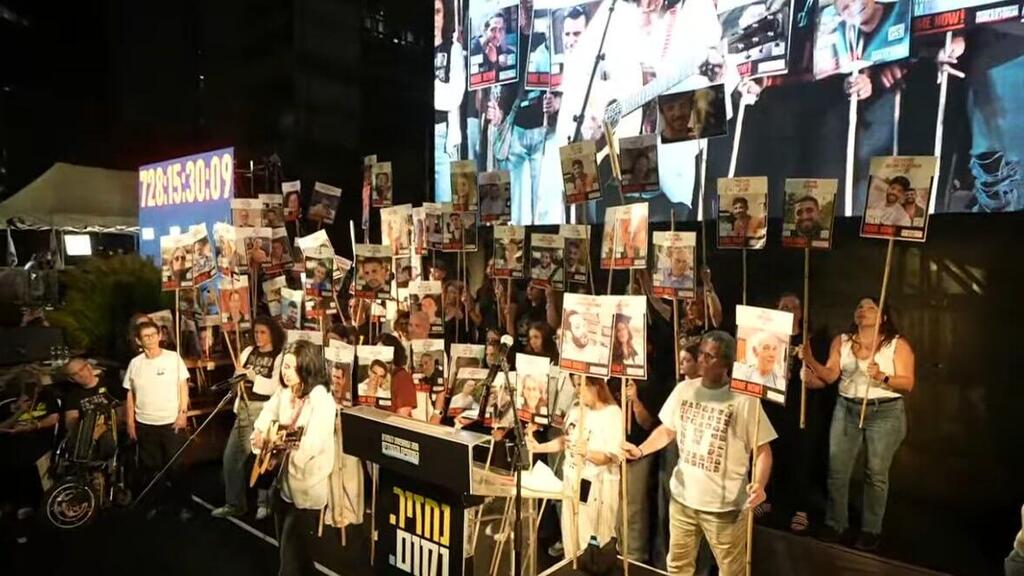 נינט שרה בעצרת, כשברקע עומדים שורדי שבי