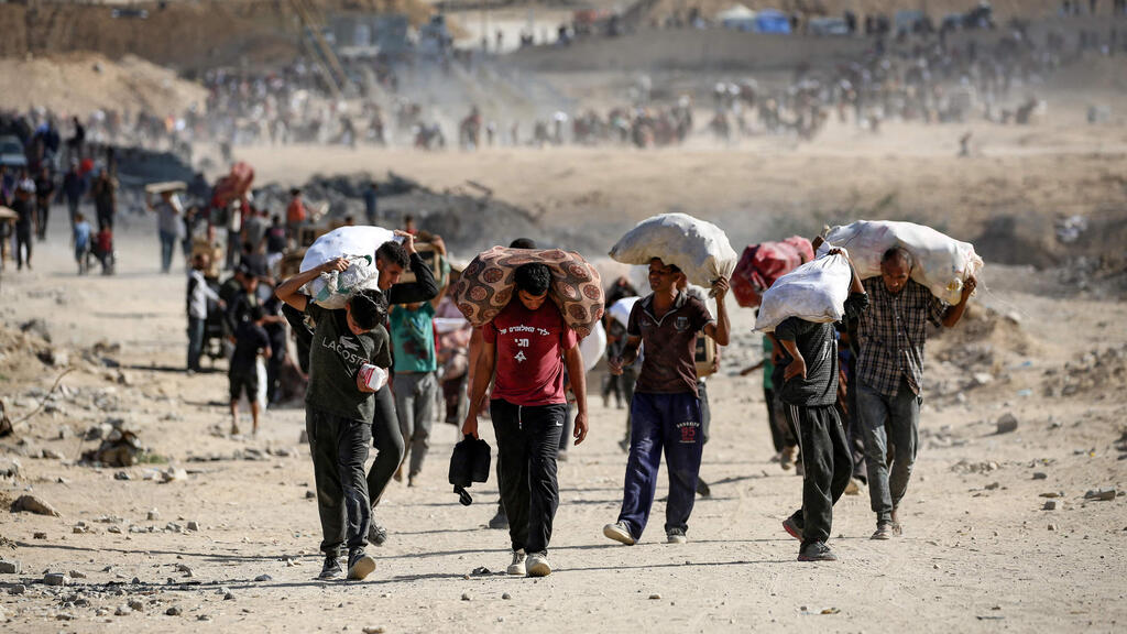 Palestinians walk away after receiving humanitarian food aid (Photo: Eyad BABA / AFP) נוסייראת