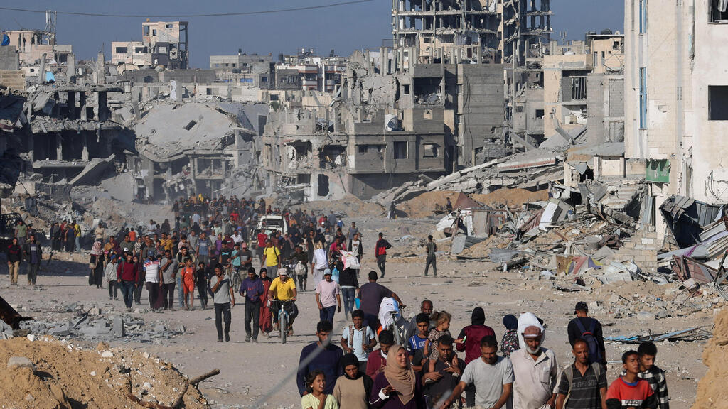 עקורים פלסטינים חולפים על פני הריסות