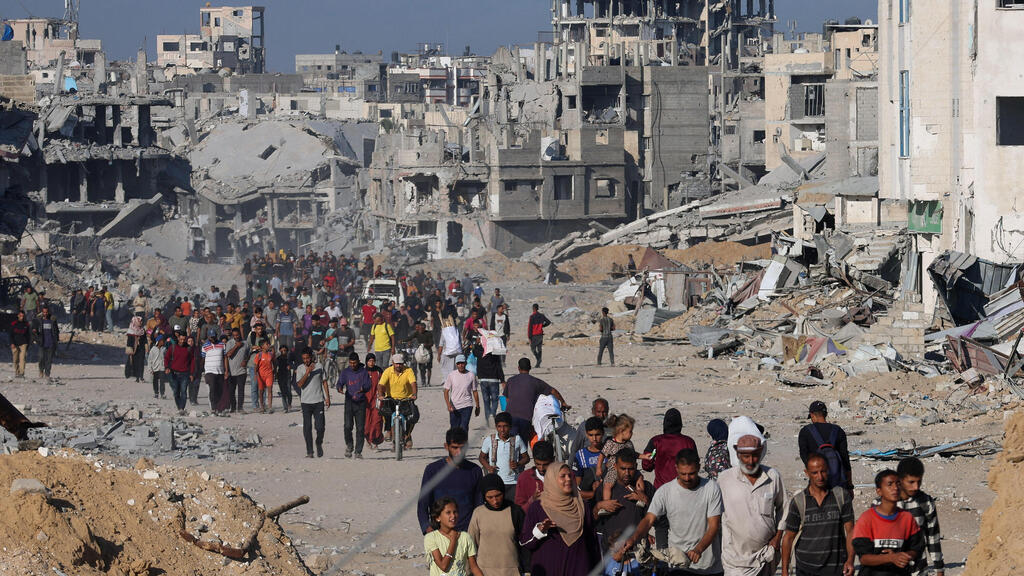 עקורים פלסטינים חולפים על פני הריסות