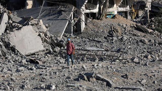 עקורים פלסטינים חולפים על פני הריסות