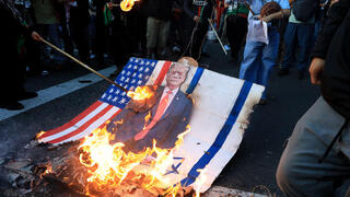 מפגינים שורפים את דגלי ישראל וארצות הברית ואת תמונתו של טראמפ במדיין, קולומביה, ב-7 באוקטובר 2025