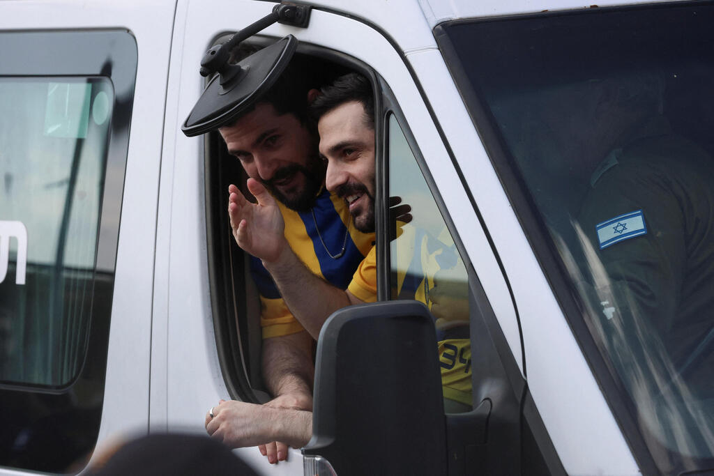 Гали и Зив Берман машут израильтянам при въезде в больницу (Фото: REUTERS/Hannah McKay) גלי ו- זיו ברמן