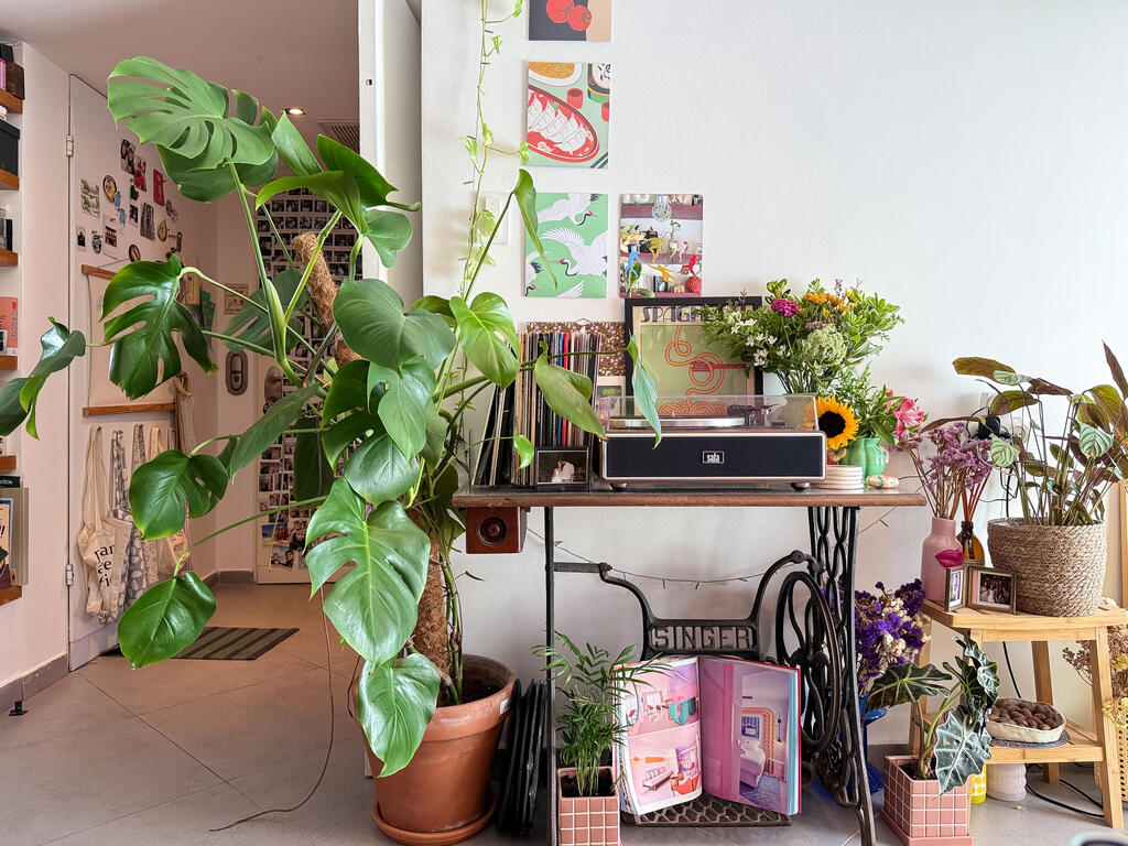 A record player and vinyls rest on an old sewing machine (Photo: Noam Ron) הדירה של אביב ונדב, מדור כאן גרים