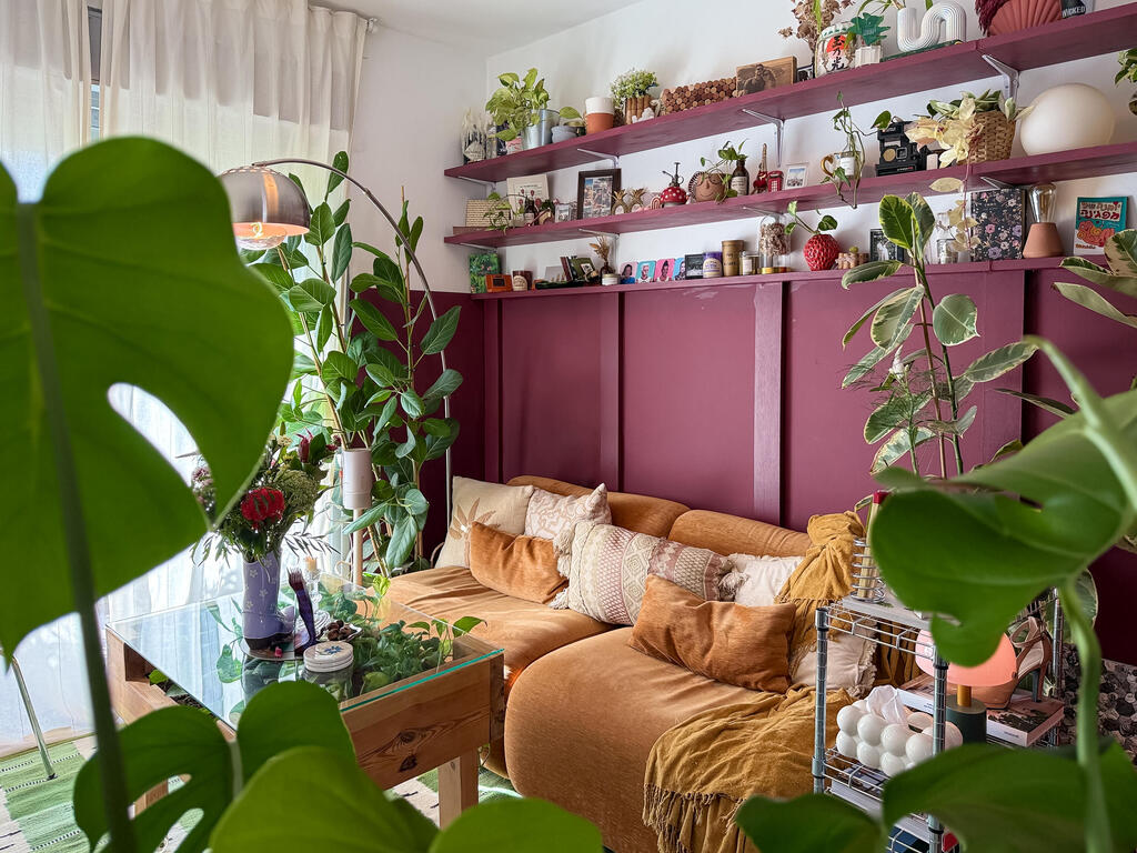 A duet of burgundy and mustard: the living room. (Photo: Noam Ron) הדירה של אביב ונדב, מדור כאן גרים