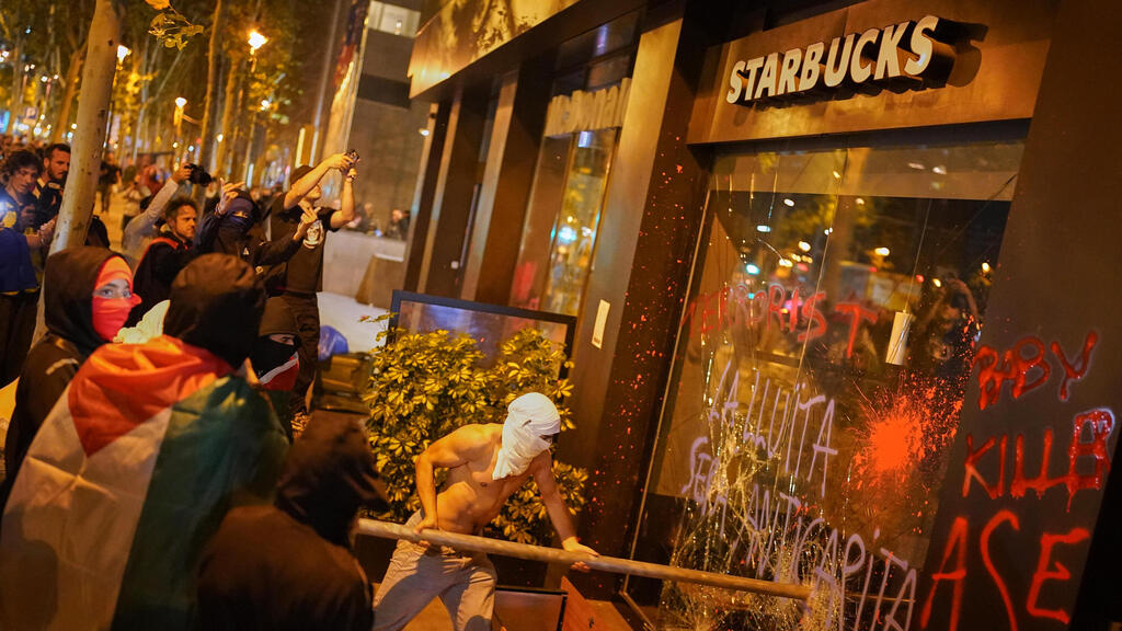 השחתה של סניף סטארבאקס (צילום: AP Photo/Joan Mateu Parra) התפרעויות בהפגנה נגד ישראל פרו-פלסטינית בברצלונה ספרד