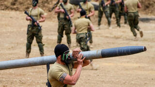 Hezbollah terrorist carrying a rocket 
